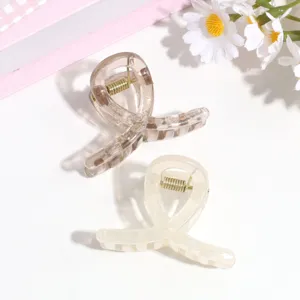 Vista detallada de pequeñas pinzas para el cabello de resina translúcida con resorte, diseño elegante.