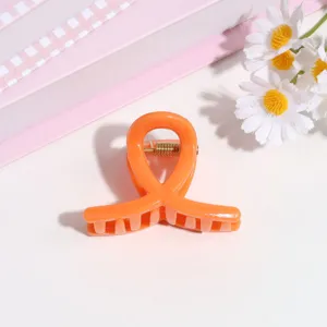 Pinza de pelo pequeña naranja, detalle de accesorio de peinado minimalista dulce y moderno.