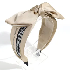 Close-up of elegant wide satin bow headband featuring classic houndstooth and rhinestone trim.