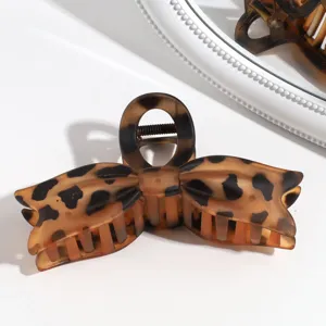 Detalle de pinza para el pelo con lazo de leopardo, accesorio mate elegante y moderno.