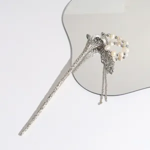 Elegant silver flower hairpin detail featuring pearls and delicate chains for chic hair styling.