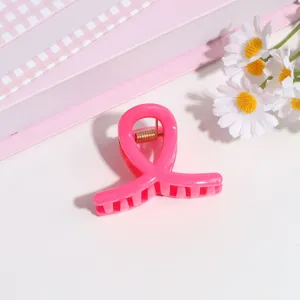 Detalle pinza de pelo lazo rosa, pequeño accesorio dulce para flequillo o peinado semirecogido.
