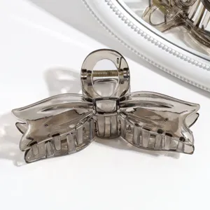 Vista detallada de pinza para el pelo con lazo gris claro, accesorio elegante y chic.
