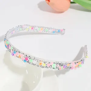 Close-up of transparent rhinestone floral hair hoop, candy color detail for sweet styles.