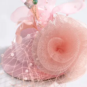 Pink mesh feather fascinator close-up, elegant vintage flower headwear detail shot