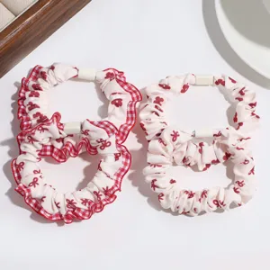 Detailed view of red checkered ruffle hair scrunchies with cute bows for women and girls daily.