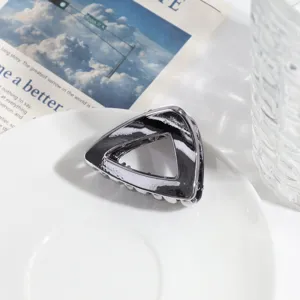 Gedetailleerd overzicht van de zilveren metalen driehoekige haarklem met modern geometrisch design.