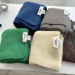 Vista dettagliata di morbide sciarpe invernali in maglia a costine in vari colori solidi da donna.