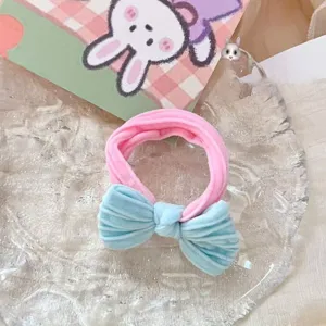 Gros plan détaillé d'un chouchou en velours doux avec bande rose et joli nœud bleu.