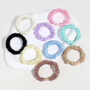 Gros plan de chouchous en satin coloré avec anneaux en plastique, accessoires pour cheveux.