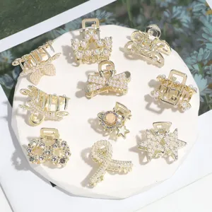 Detailed view of elegant gold alloy small hair claws with faux pearls and sparkling rhinestones.