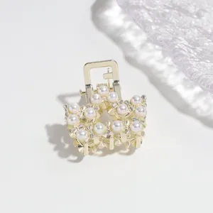 Elegant gold-tone metal mini hair claw clip decorated with delicate faux pearls for women.