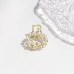 Pearl rhinestone small hair claw clip detail shot, elegant golden alloy design for half-up hair.