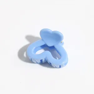 Detail shot of light blue heart hair claw clip, cute mini hair accessory for styling.