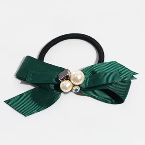 Green ribbon hair tie detail featuring pearl and cute bear charm for elegant daily hairstyles.