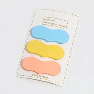 Close-up detail of sweet candy color hair clips on white card, fresh style hair accessories.