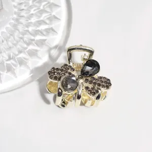 Detailed shot of sparkling rhinestone small hair claw clip alloy hair accessory for styling.