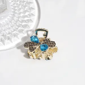 Close-up detail of the elegant rhinestone hair claw clip, sparkling blue crystals and clear stones.