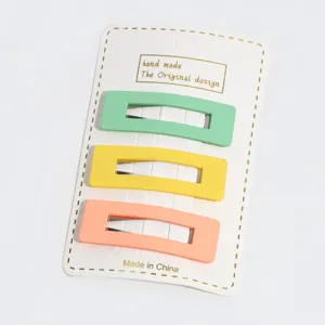 Detail close-up shot of minimalist rectangular candy color hair clips on display card.