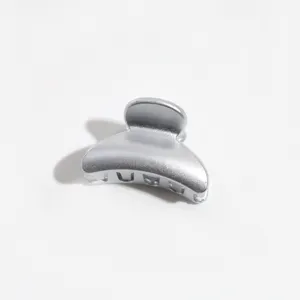 Close up of a mini silver hair claw clip, compact hair accessory for bangs and styling details.