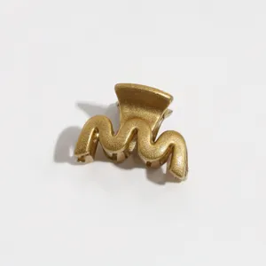 Detailed close-up view of a stylish gold wavy hair claw clip designed for daily styles.