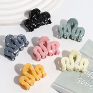 Detailed view of colorful wavy hair claw clips with stylish splatter pattern design.