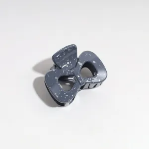 Detail view of the grey blue bow hair claw with silver splatter spots for everyday use.