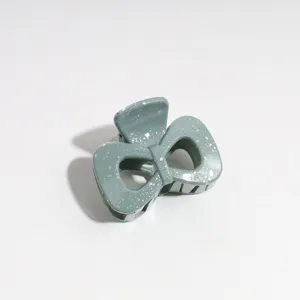 Detailed view of a stylish Morandi green bow hair claw clip with silver speckles, perfect for use.