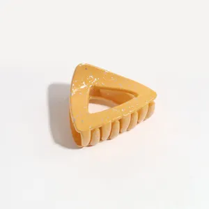 Triangle hair claw clip detail shot, yellow with silver speckles, secure ponytail hair accessory.