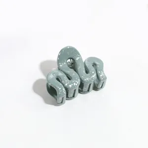 Green irregular hair claw clip with silver splatter design, stylish hair accessory for women.