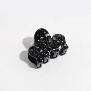 Detailed close-up of a black glitter wave hair claw clip, stylish hair accessory for women.