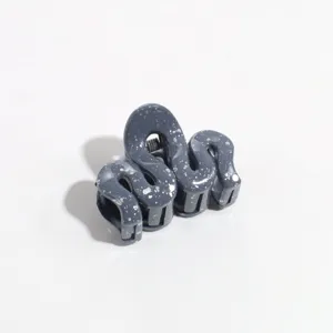 Close-up view of grey abstract wave hair claw clip, stylish daily hair accessory.