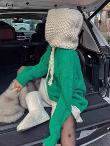 Detailed view of the thick knitted balaclava with braided ties in a lifestyle car setting