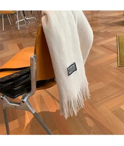 Cozy winter knitted scarf with fringe detail, elegant warm fashion accessory for women.