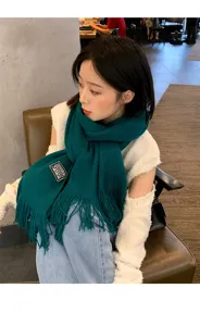 Women winter knitted scarf detail shot, cozy green tassel design, stylish daily warm neck wrap.