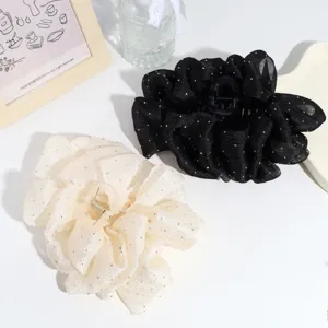 Detailed view of large mesh flower hair claw clips with sparkling rhinestones in black and beige.