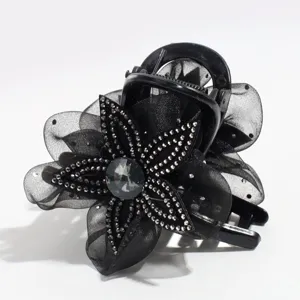 Close-up detail of black mesh flower hair claw clip featuring sparkling rhinestones and crystal.