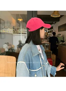 Detailed lifestyle view of a pink washed cotton baseball cap worn in a cozy cafe setting.