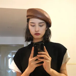 Brown PU leather beret detail showing the fine texture and stylish retro design worn by model.