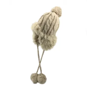 Cappello trapper in maglia beige con paraorecchie in pelliccia sintetica morbida invernali.