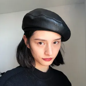Detail view of a black PU leather beret, classic vintage painter hat for autumn and spring.