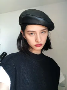 Classic black PU leather beret for women, vintage British style chic painter hat detail view.