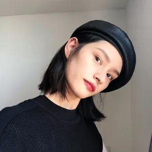 Close-up detail shot showing texture of black PU leather beret, stylish headwear accessory.