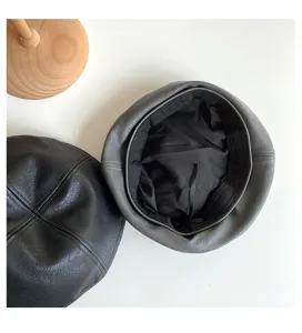 Detailed view of PU leather beret interior lining and exterior texture in black and gray.