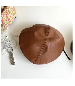Brown PU leather beret detail view, vintage painter hat style, textured surface.