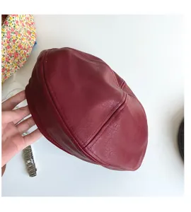 Dark red PU leather beret detail view, classic retro painter hat showing texture and stitching.