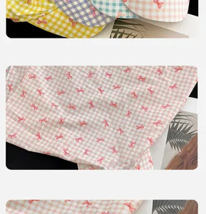 Close-up detail of plaid triangular headscarf with cute small red bows for summer.