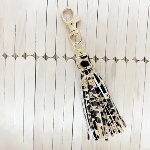 Detailed close-up view of the leopard print PU leather tassel keychain with gold hardware.