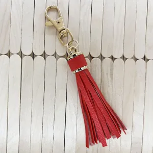 Red PU leather tassel keychain detail showing the gold metal clasp and long fringe texture.
