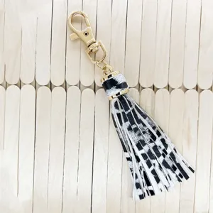 Black and white animal print PU leather tassel keychain detail accessory for bags and keys.